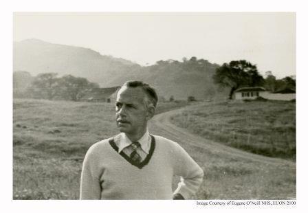 Eugene O'Neill, and older man, poses outside against a hilly background.