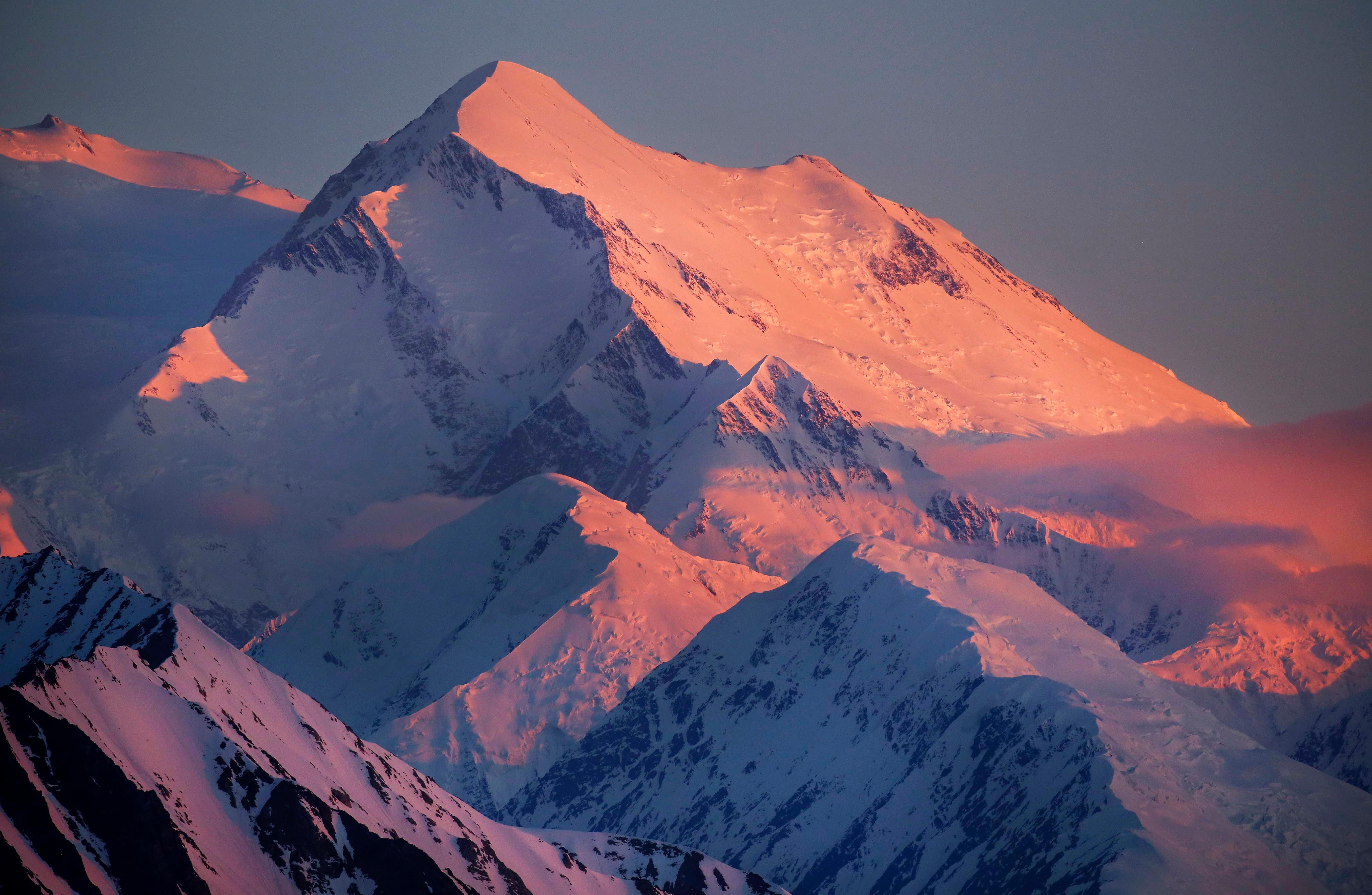 light turns a snowy mountain shades of pink and purple