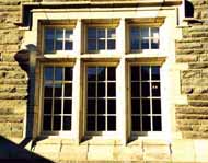 This shows the cleaned stonework and matching new replacement windows after rehab.