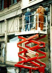 Here, workers are shown stripping and scraping the wood transom