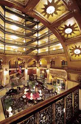 This is a dramatic image of the ornamented interior of a 19th century hotel, looking down to the sitting lobby, and up to its connected floors. The image rolls over to provide the correct answer. Screen Reader users see text-only link, left, for answer. Photo:  Courtesy, The Brown Palace Hotel, Denver, Colorado.