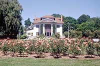 This is an image of a historic residence in the background and rose garden in the foreground. Photo: Courtesy, Oregon State Historic Preservation Office.