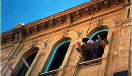 This is an image of a worker priming a window frame of a historic commercial building. Photo: Courtesy, Sidway Development Corp.