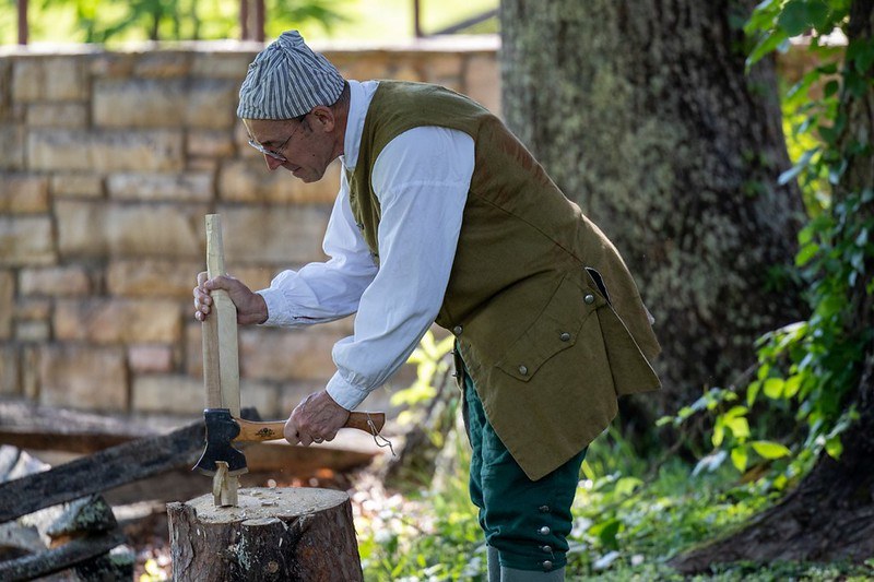 Man in 1700s period clothing doing woodcarving