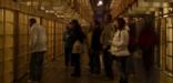 游客在恶魔岛的夜游中凝视着排列在走廊上的许多牢房，这些牢房被称为 