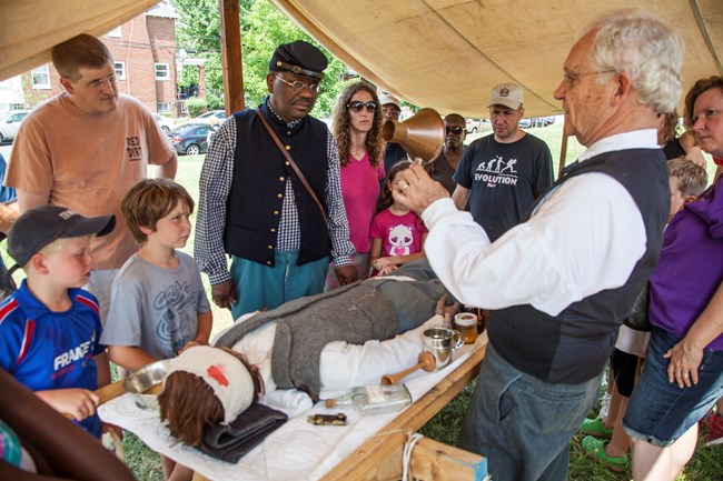visitors look at a Civil War medicine demonstration