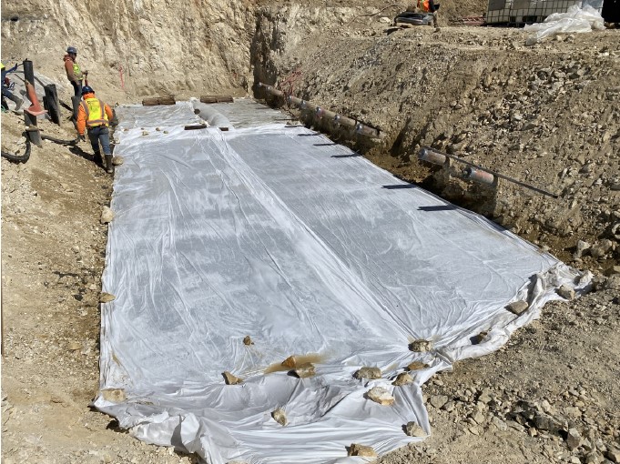 A long, rectangular grout pad is covered with a plastic sheet