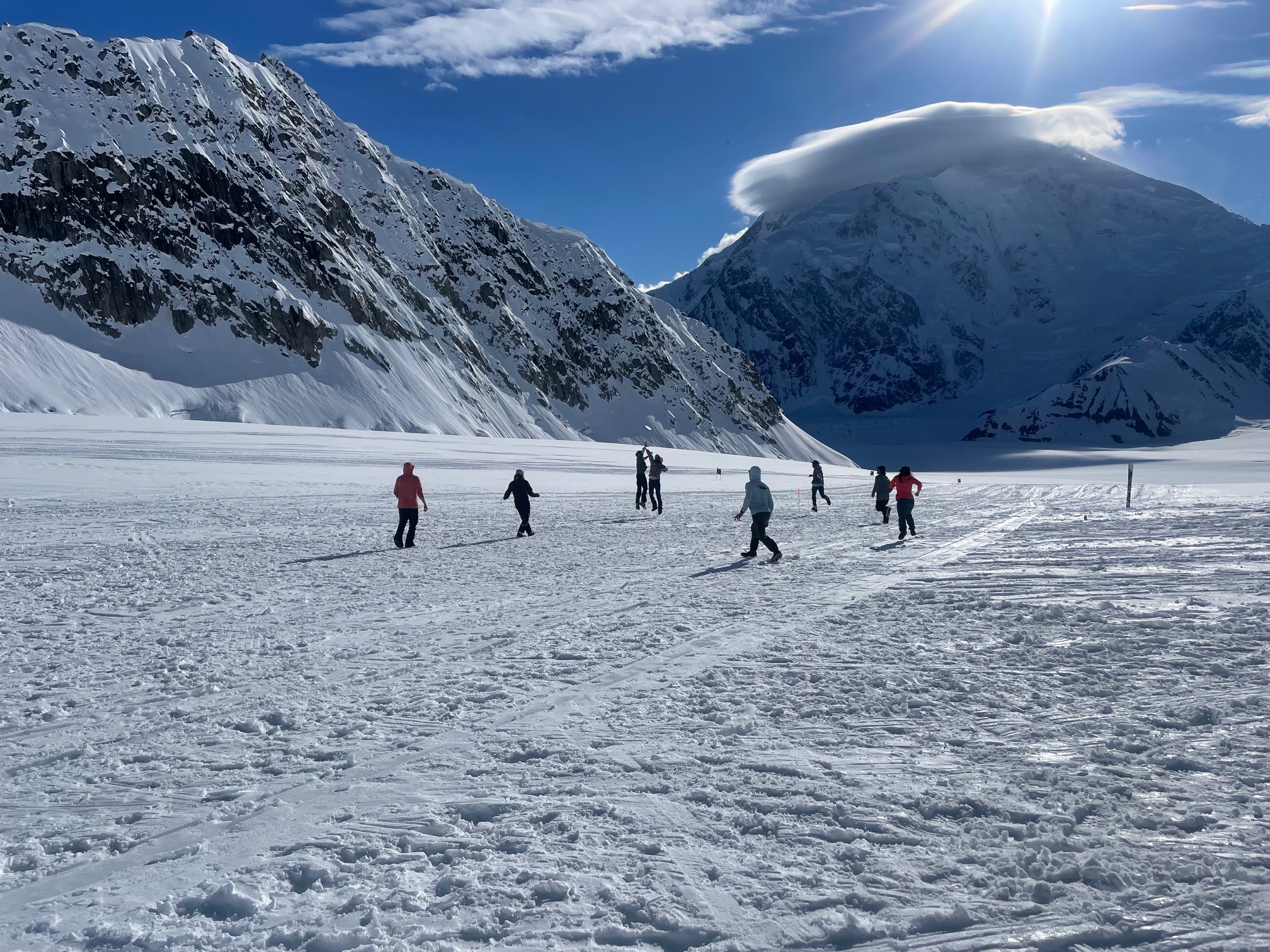 A group of climbers play a game of ultimate frisbee on the Kahiltna Glacier