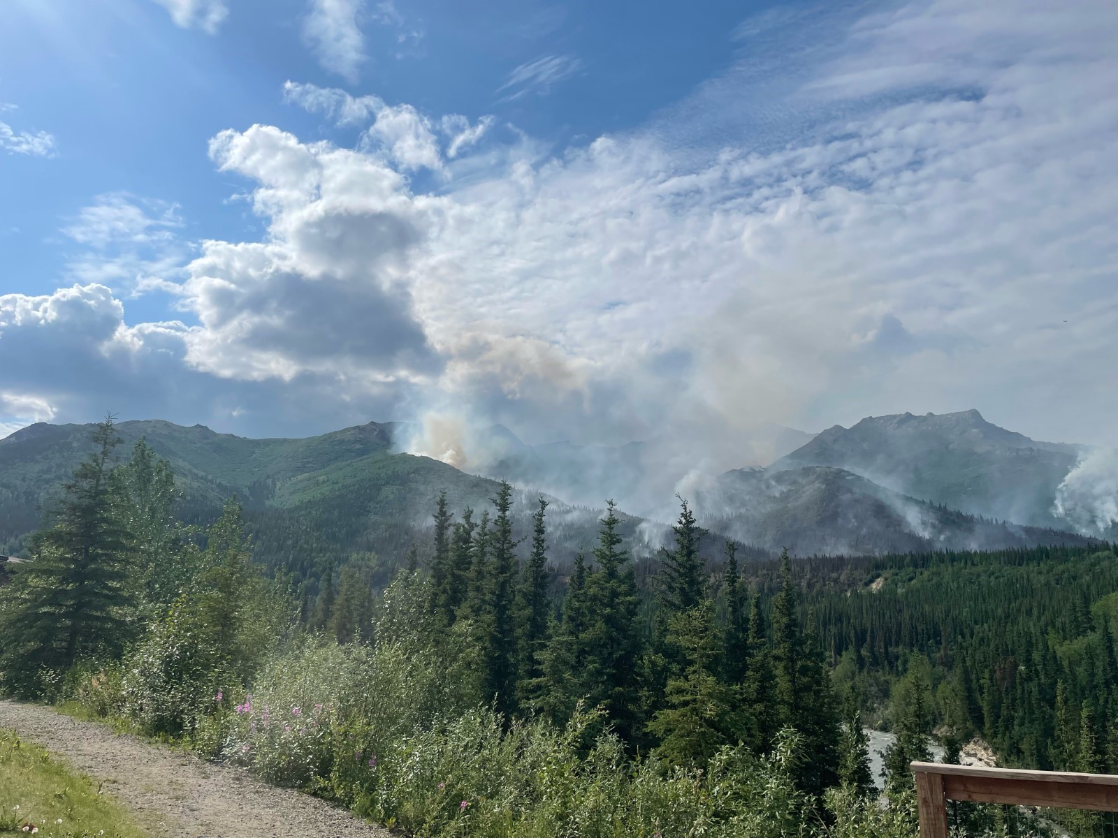 Panoramic view of wildfire. Smoke rising from mountains.