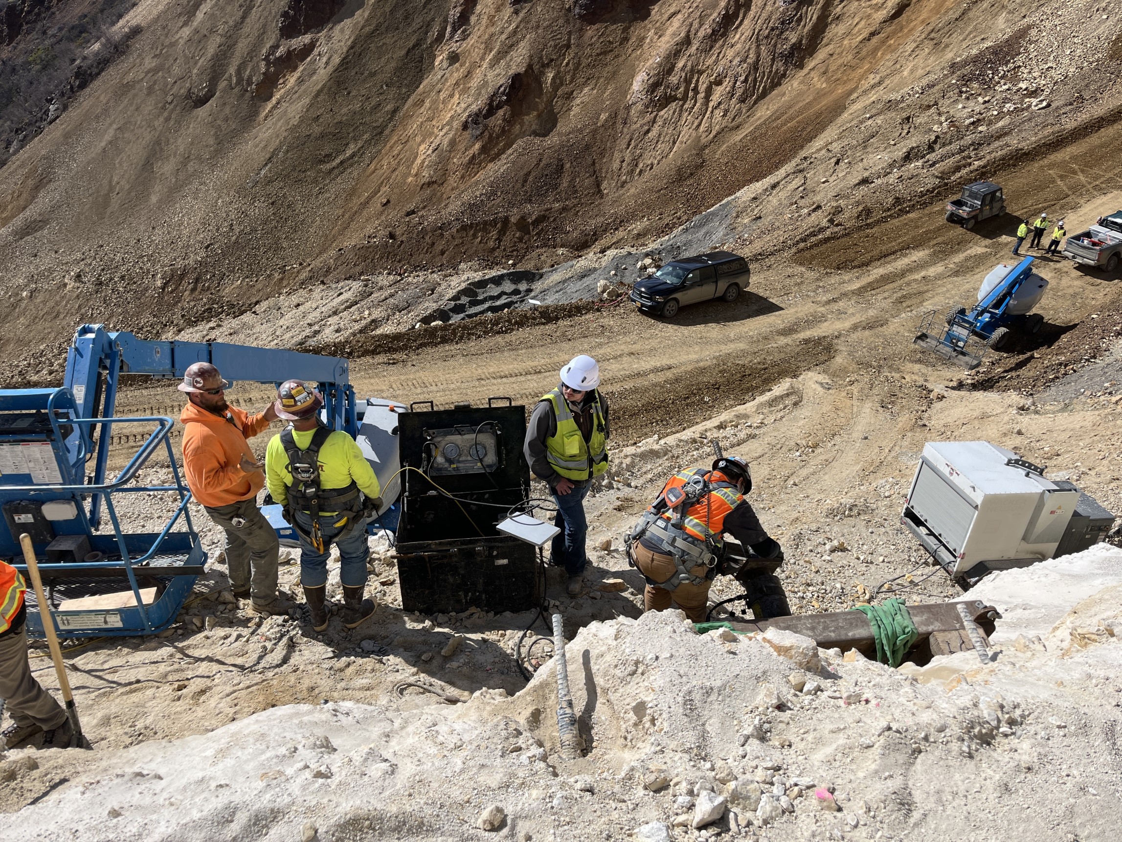 Several construction vehicles and a crane on the east side of the landslide.