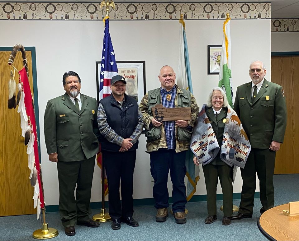 National Park Service and Iowa Tribe of Kansas and Nebraska leaders hold plaque recognizing sister park agreement.