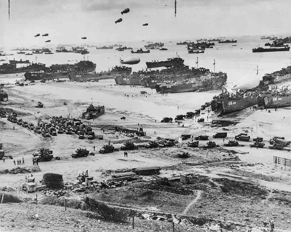 A very busy aerial picture of Normandy Beach, France in 1944 as dozens of Allied transport ships unload their cargoes of tanks, vehicles, and soldiers.