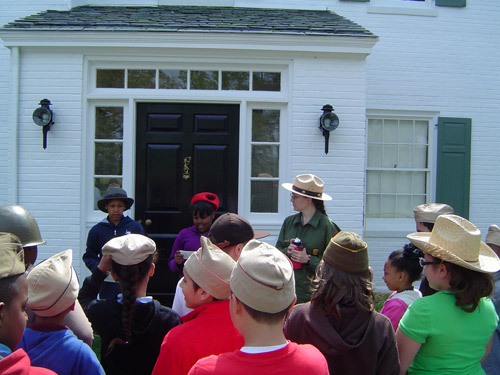 Students participating in the Eisenhower:Man of Many Hats program are welcomed to the Eisenhower home by the President and First Lady.