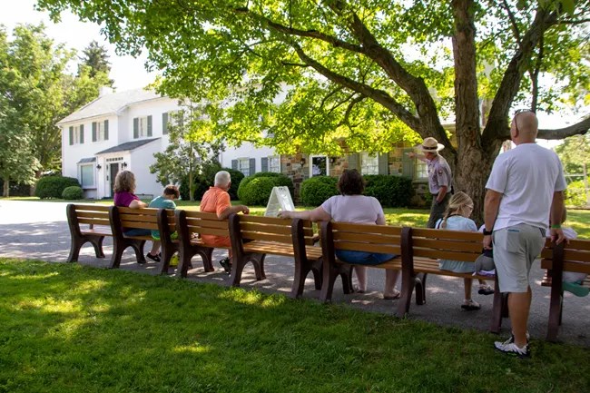 A group of visitors listens to a house tour outside the Eisenhower home