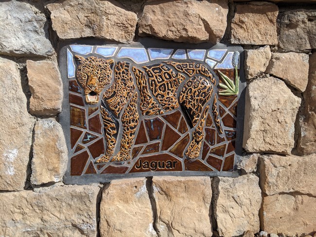 Jaguar Mosaic, the first of the mosaics on the wall up to the “high road” represent the things travelers may have seen as they traveled the 1600 miles on El Camino Real de Tierra Adentro. As you walk along the path, look for the twelve art pieces.