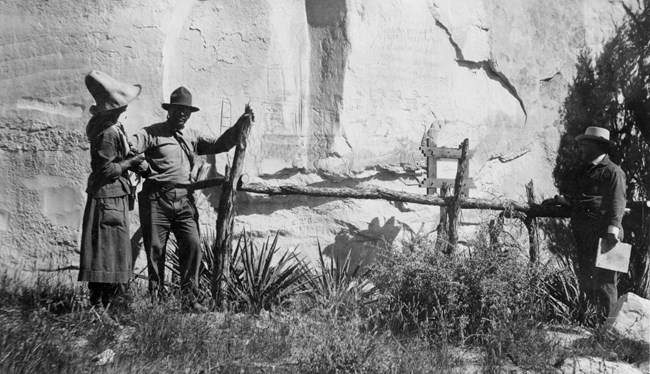 A park ranger shows a visitor the inscriptions.