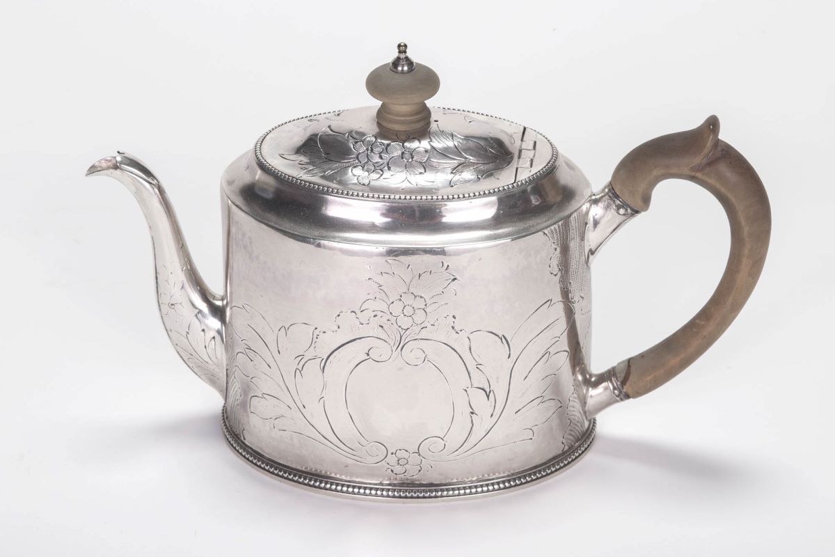 A silver teapot with wood handle
