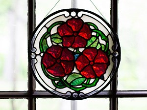 A medallion with stained glass in form of three flowers.