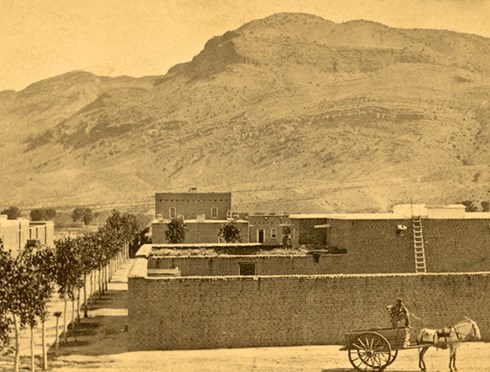 historical photo of the view of a fort and a mountain in the back