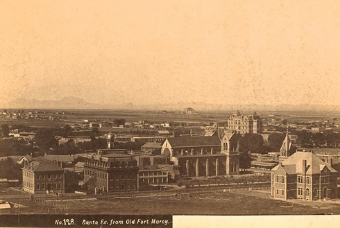 old photograph of the view of santa fe city, with old style structures and a church