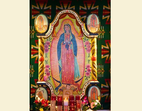 painting of virgin mary and candles adorning it