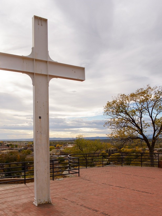 image of tall white cross with views of mountains