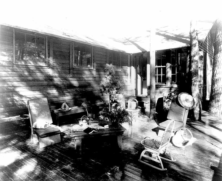 Porch with four chairs and a table.