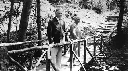 Herbert and Lou Henry Hoover standing on the footbridge over Mill Prong.