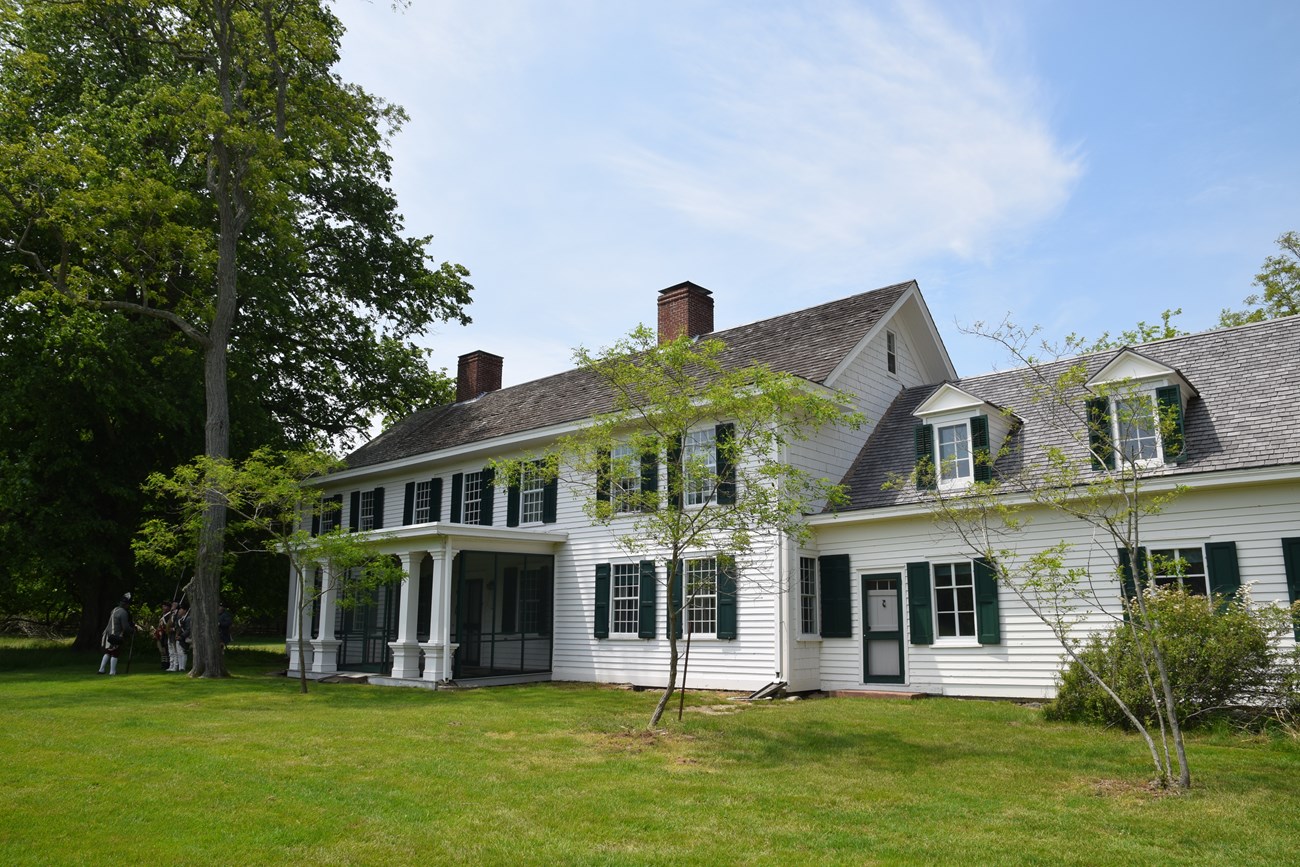 An historic home surrounded by lush green vegetation.