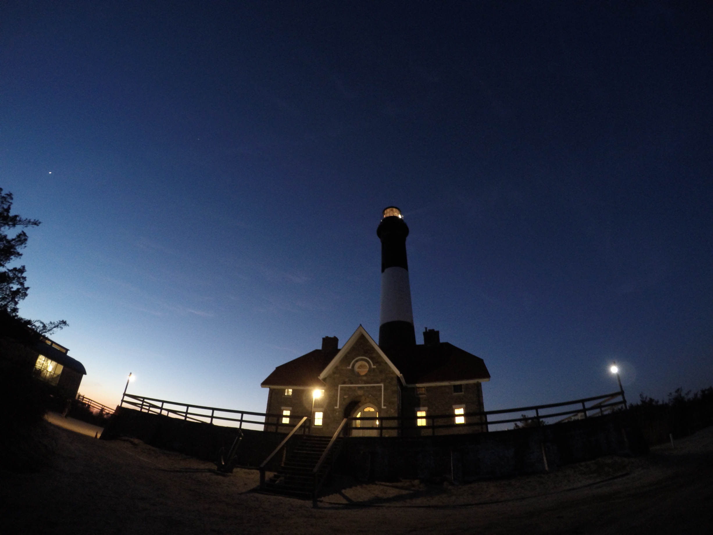 The Fire Island Lighthouse lit up against the night sky.