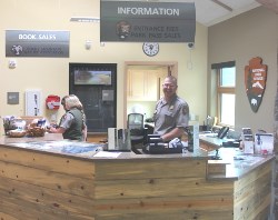 Park Ranger stands behind an information desk.