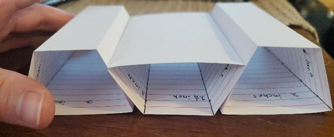 The two outer index card blocks are further apart. The middle card has fallen down so that its top is lower than the other two.