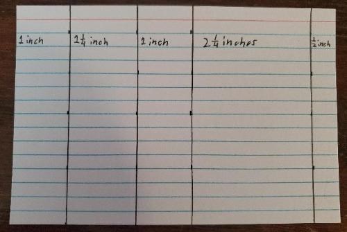 An index card divided into measured sections by straight lines drawn in pen.