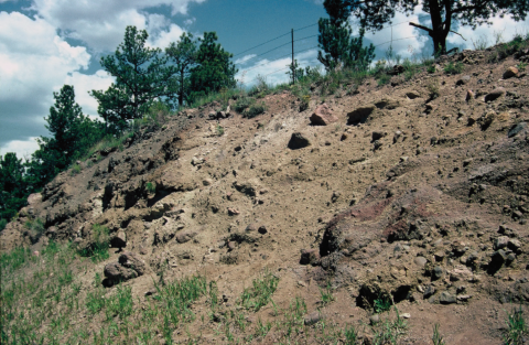 Volcanic Lahar Dam Roadcut Roadcut featuring rocks ranging in size from large boulders to pebbles under hillside