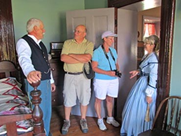 Volunteers in period clothes talking to visitors.