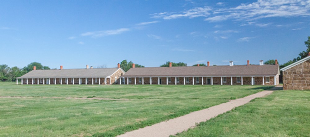 Front view of the two rectangular barracks buildings from across the parade ground.