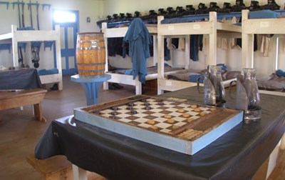 Room with wooden bunk beds in background, checkerboard on a table in foreground.