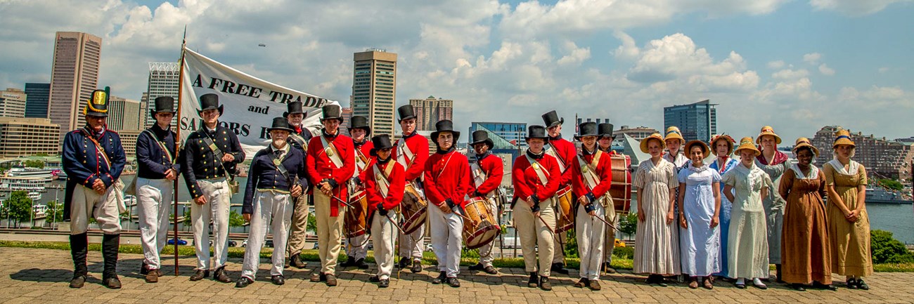 Living historians in War of 1812 uniforms and dress with Baltimore skyline