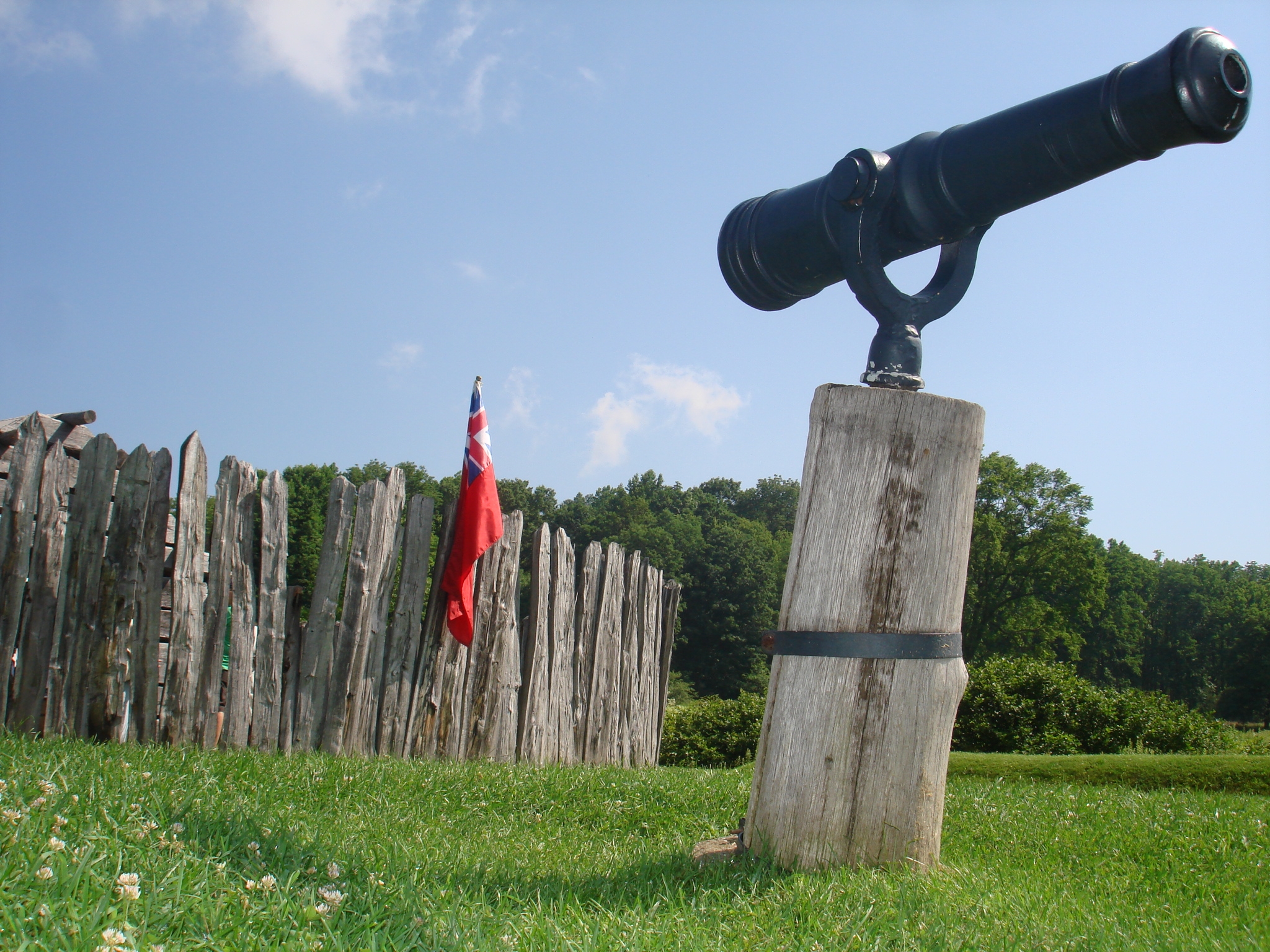 Image of a swivel gun in front of fort wall.