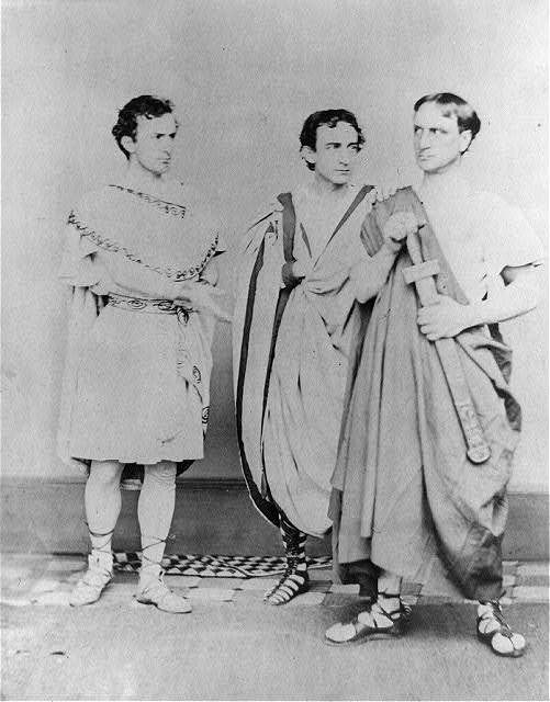 Booth Brothers in Julius Caesar Three men stand together wearing Roman-style flowing robes and sandals