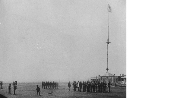 troops assembled beneath tall flagstaff