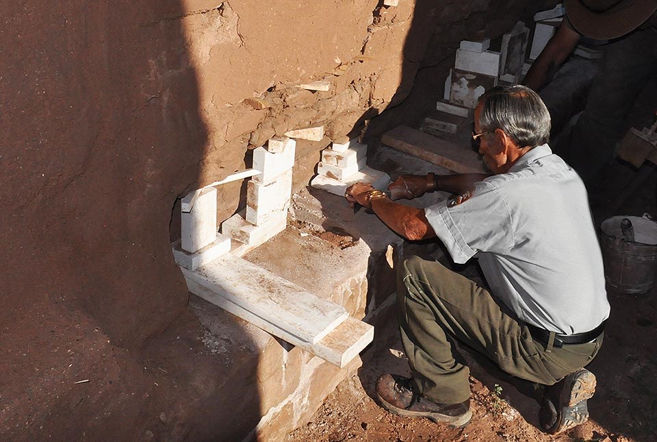 A member of the Fort Union preservation crew works on an adobe wall.