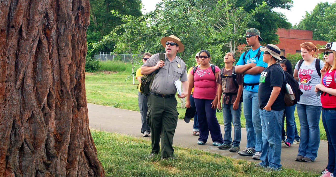 teacherrangerteacher Park Ranger guides students around sequoia tree outdoors