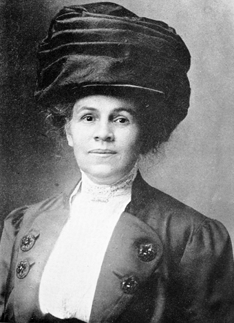 A black and white photo of a woman with a large hat.