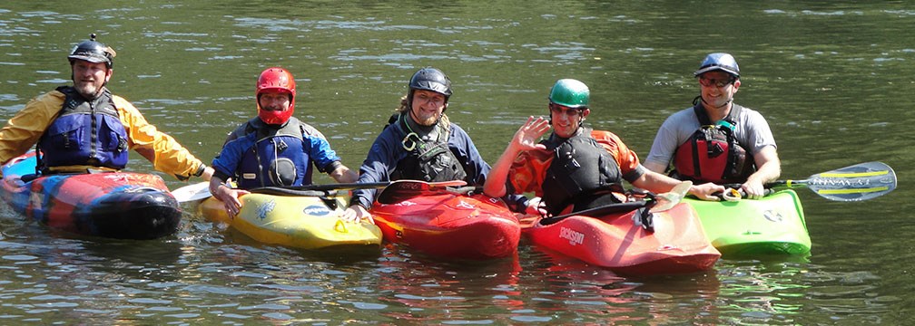 five kayakers on a river