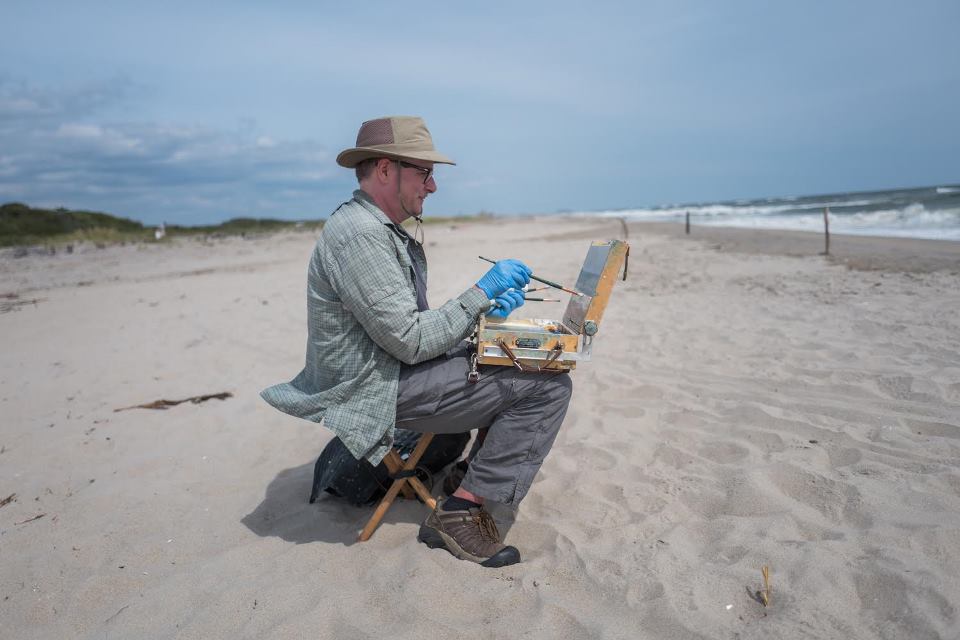 Photo of artist Christopher Wright painting at Fort TIlden