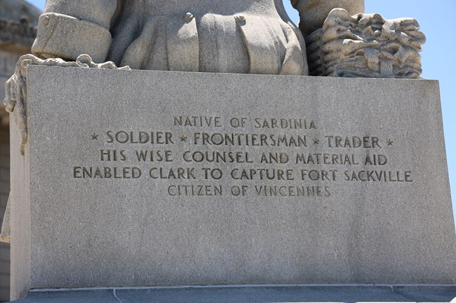 Text on the back side of the Vigo Statue: Native of Sardinia * Soldier * Frontiersman * Trader * His wise counsel and material aid enabled Clark to capture Fort Sackville. Citizen of Vincennes
