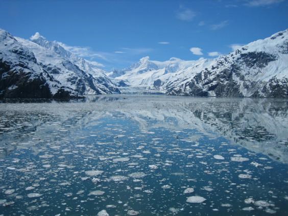 A view of a tidewater glacier and tall snow-covered mountains