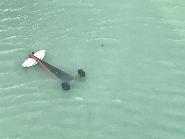 Plane partially submerged, upside-down, in a lake