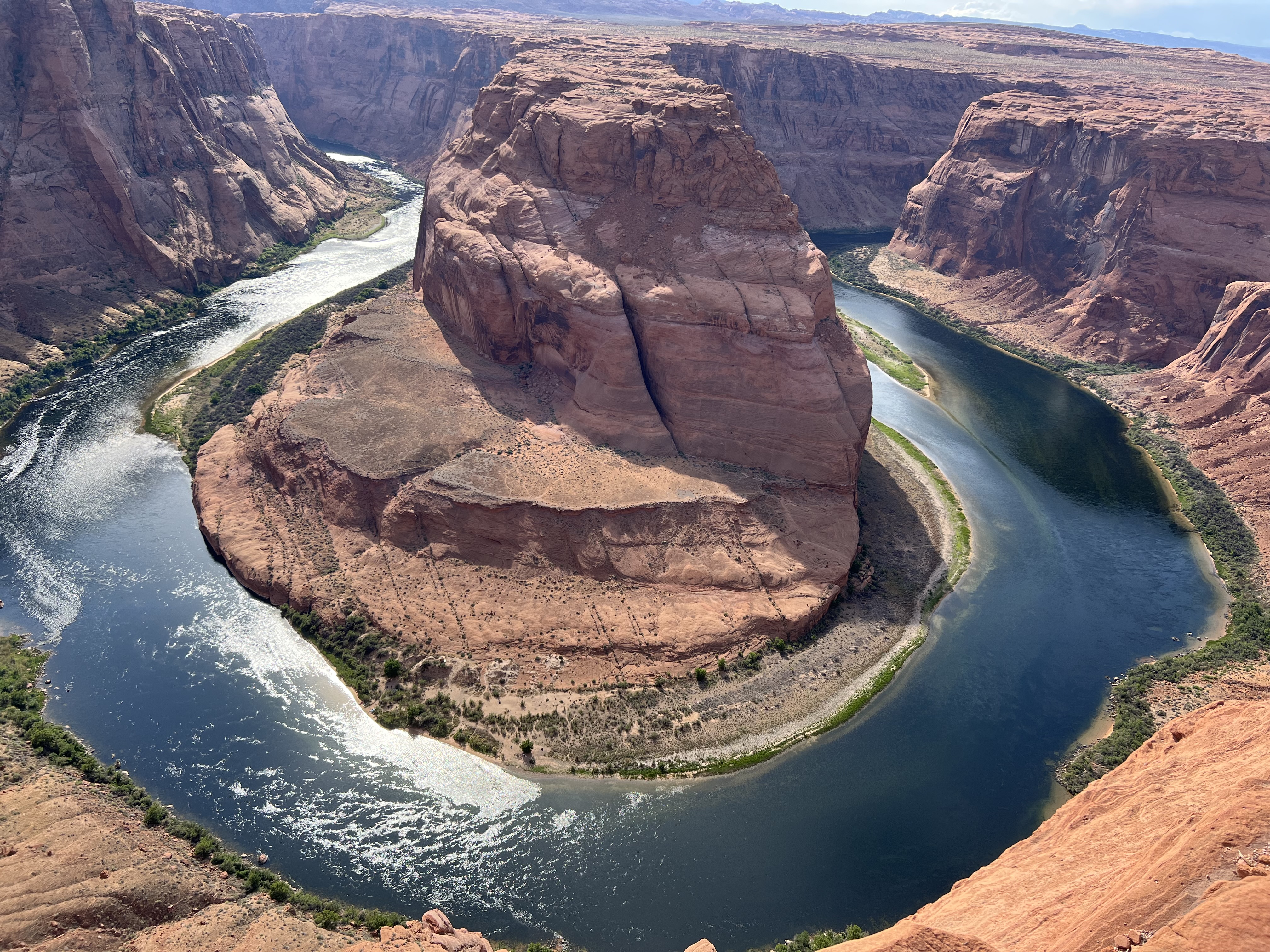 A clear river makes a perfectly round curve in the sandstone canyon.